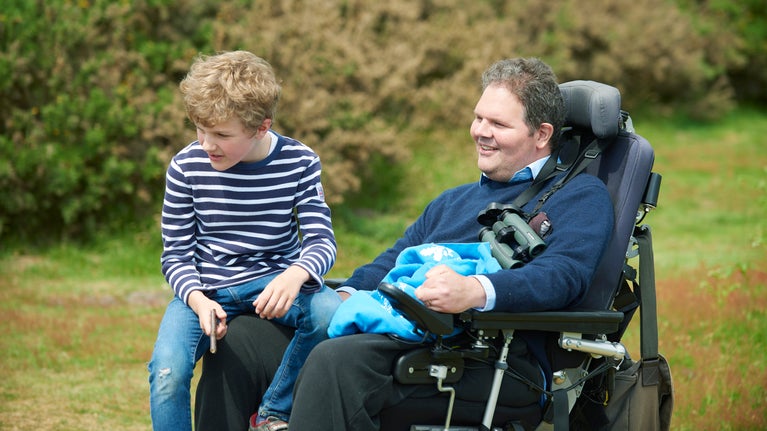 A child and a man using a mobility aid at Dunwich Heath and Beach, Suffolk